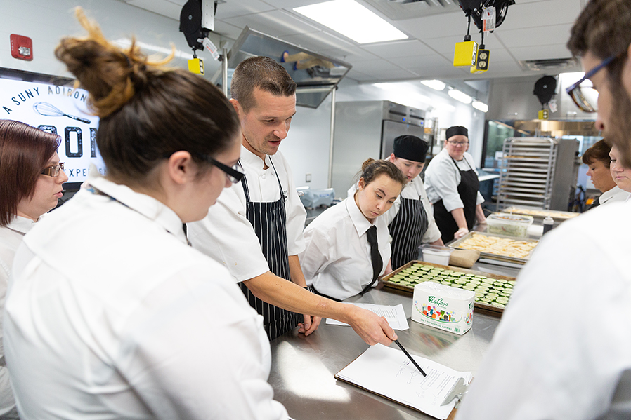 Chef Matt Bolton works with SUNY Adirondack culinary arts students in the kitchen at Seasoned in downtown Glens Falls.