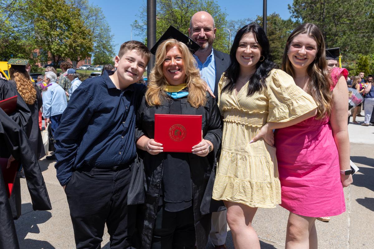 Family posing at graduation with a Plattsburgh graduate