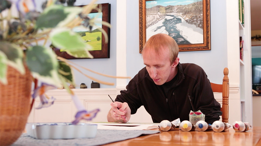 SUNY Adirondack alumnus Jacob Houston paints at his dining room table in Greenwich.