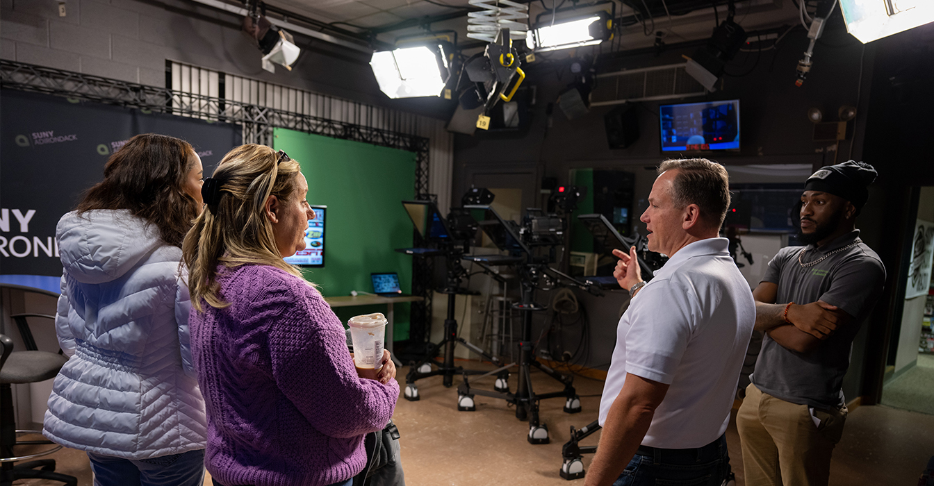 Image of prospective students and their families in the broadcast studio with Professor Ankeny
