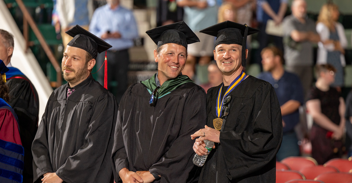 Chef Matt Bolton, Professor Nick Ameden and Professor Brandon Segal smiling at graduation