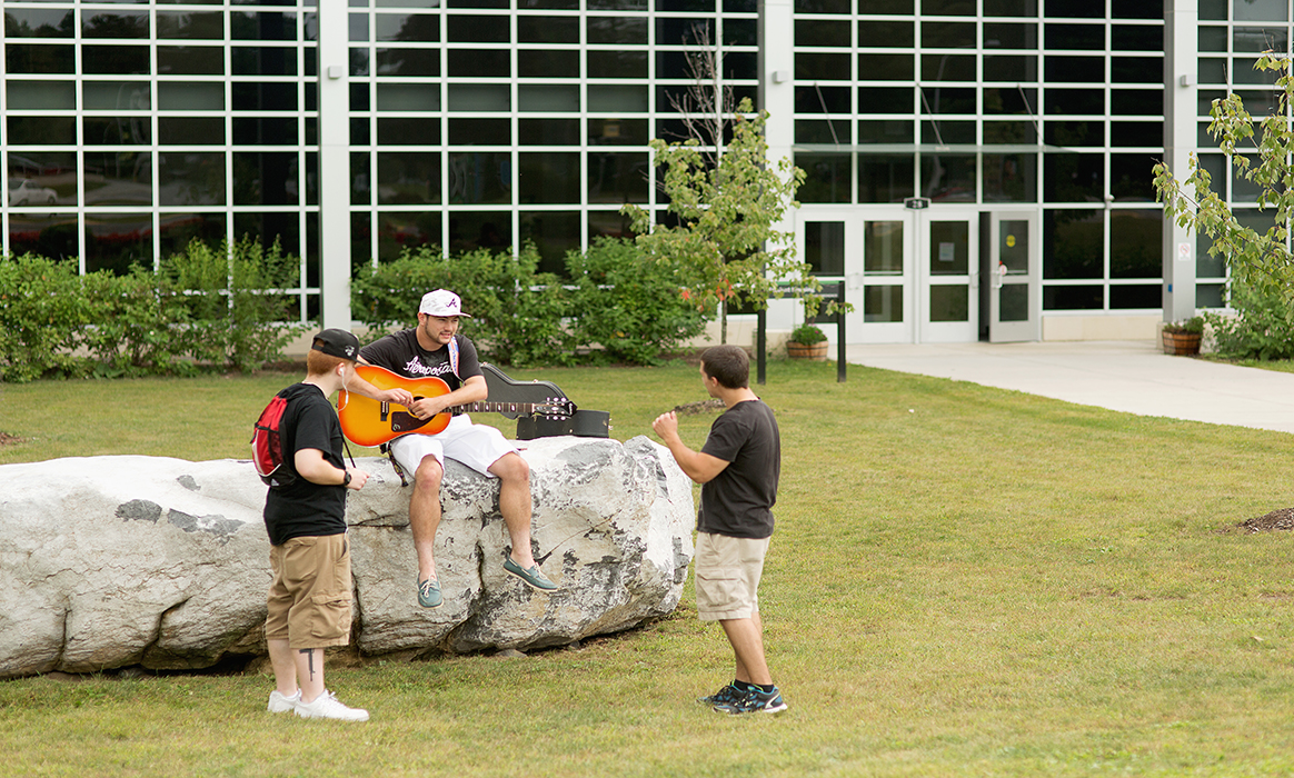 Three students are seen in front of the Residence Hall