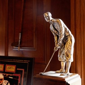 A trophy of a golfer is displayed on a table inside Hiland Country Club