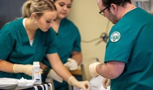 Students in a health care course work on care techniques