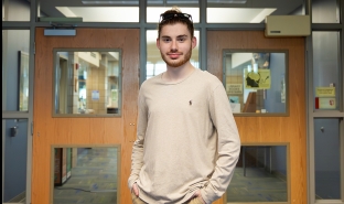 Parker Kaliesz stands in the Library in Scoville Learning Center