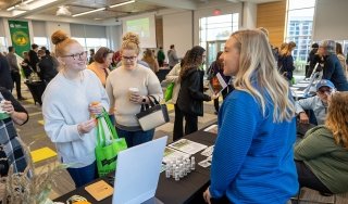 Kim Comisky, director of Healthcare Pathways at SUNY Adirondack, discusses program offerings with attendees at a college Open House event.