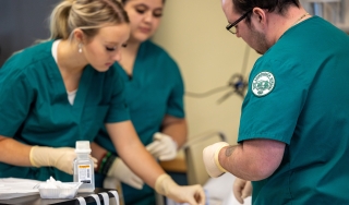 Students in a health care course work on care techniques
