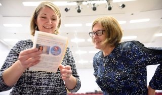 Mary McDermott looks over a program at a Nursing pinning ceremony.