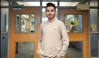 Parker Kaliesz stands in the Library in Scoville Learning Center