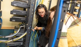 Two students work on a project in a networking lab