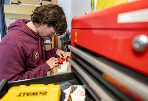 A student works on a piece of equipment in the Advanced Manufacturing labs on campus.