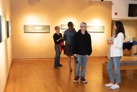 Students and faculty viewing art in the gallery