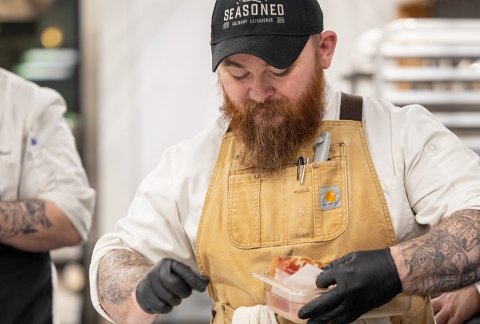 A student plates food at Vintners Night 2025