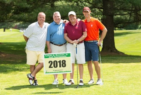 A team of golfers poses for a photo in 2018