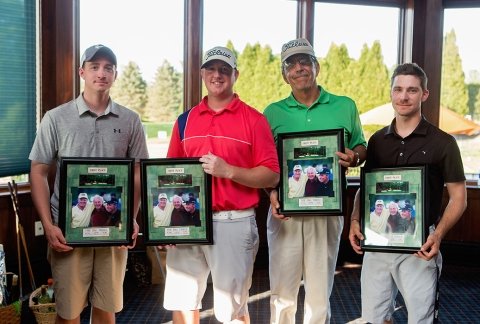 Four men proudly pose with first-place plaques