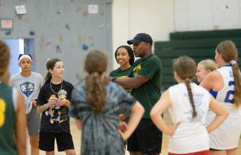 SUNY Adirondack Women's Basketball Coach Cornelius Tavarres talks to a group of youth basketball players