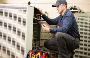 A man works on an air conditioning unit