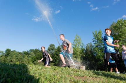 Children shoot a water rocket on a sunny summer day
