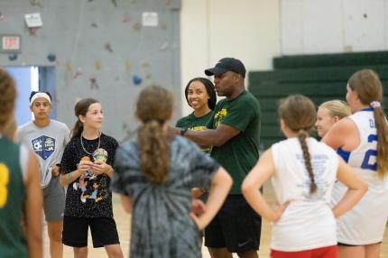 SUNY Adirondack Women's Basketball Coach Cornelius Tavarres talks to a group of youth basketball players
