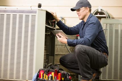 A man works on an air conditioning unit