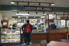 A young man stands at the counter of Einstein's