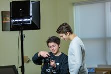 Two students adjust camera settings in a photography studio